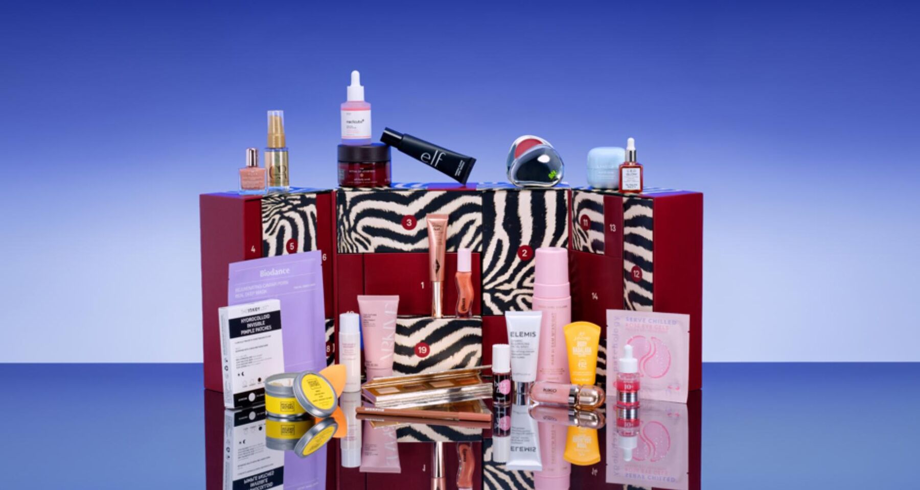 The zebra-print ASOS Face and Body advent calendar 2026 open with its 25 beauty products arranged around it on a blue background