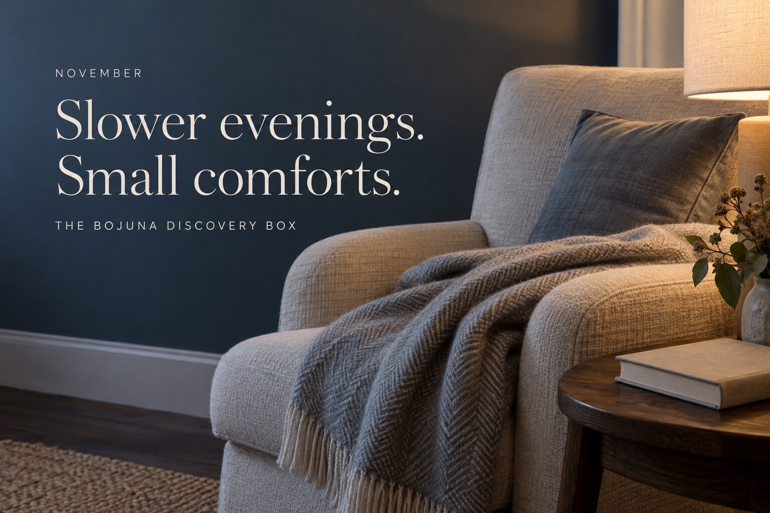 A cosy living room at dusk with a lamp, an armchair and a throw, with the words Slower evenings, small comforts