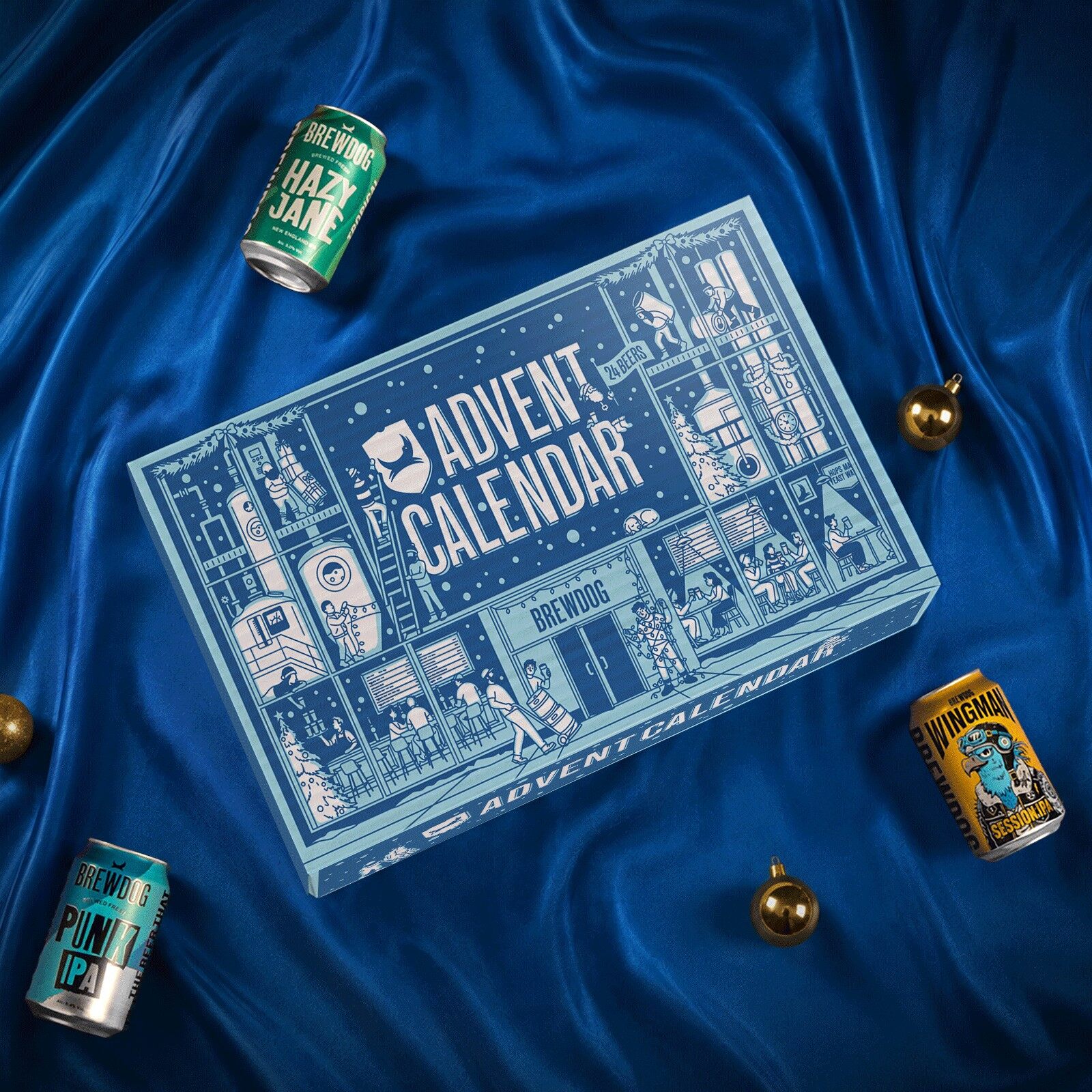 The pale blue BrewDog advent calendar 2026 lying on blue satin with cans of Hazy Jane, Punk IPA and Wingman