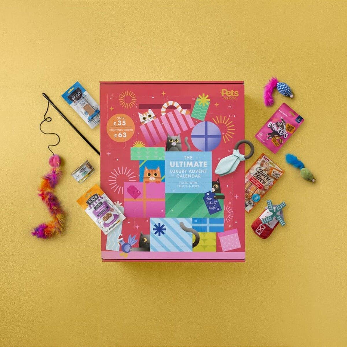 The pink Pets at Home Ultimate Luxury advent calendar for cats on a gold background, surrounded by cat toys and treats