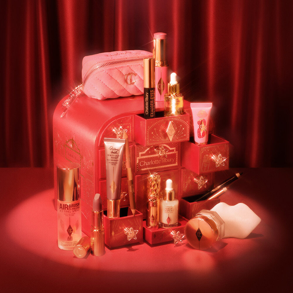 The open Charlotte Tilbury Hollywood Beauty Wonderland advent calendar 2026 with make-up products and a pink bag on a red stage