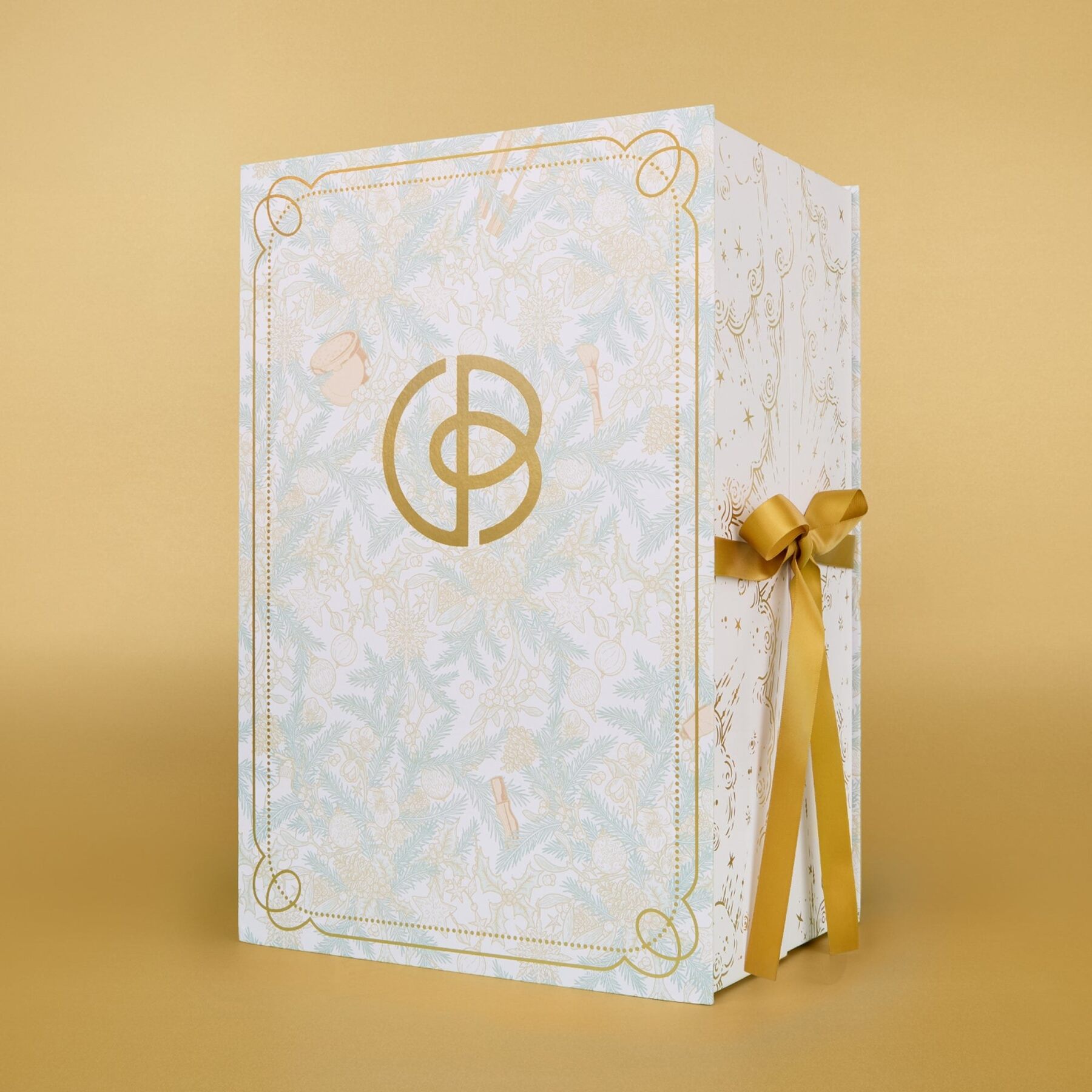 The closed Special Edition calendar, an illustrated white and gold box tied with a gold ribbon, on a gold background
