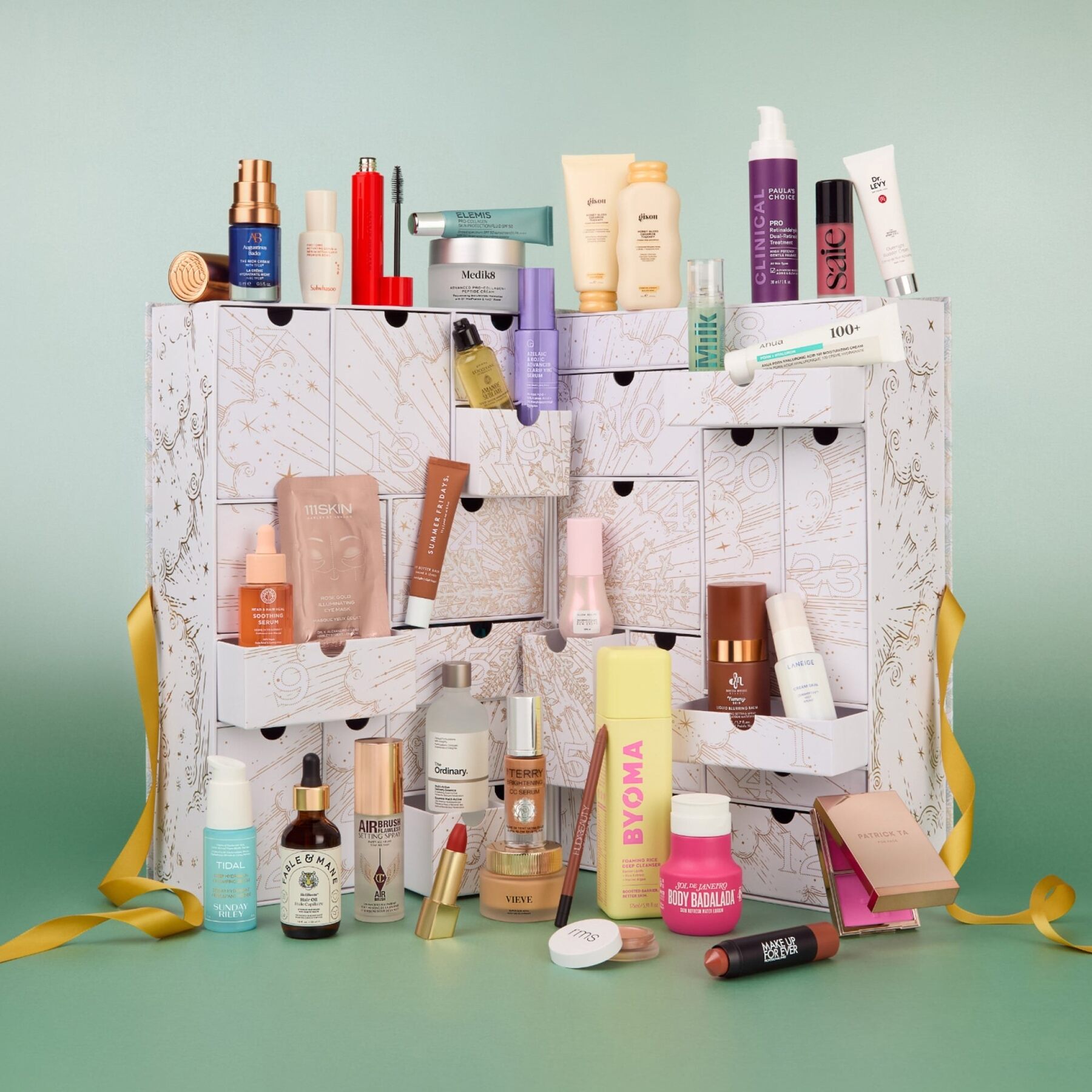The open Cult Beauty advent calendar 2026 with its drawers spilling beauty products, on a green background