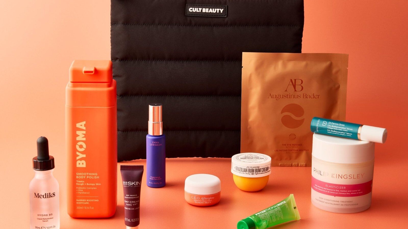 The Cult Beauty New Season Selects Goody Bag products arranged in front of a black quilted pouch