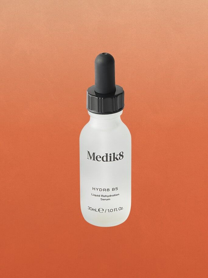 A bottle of Medik8 Hydr8 B5 serum on an orange background