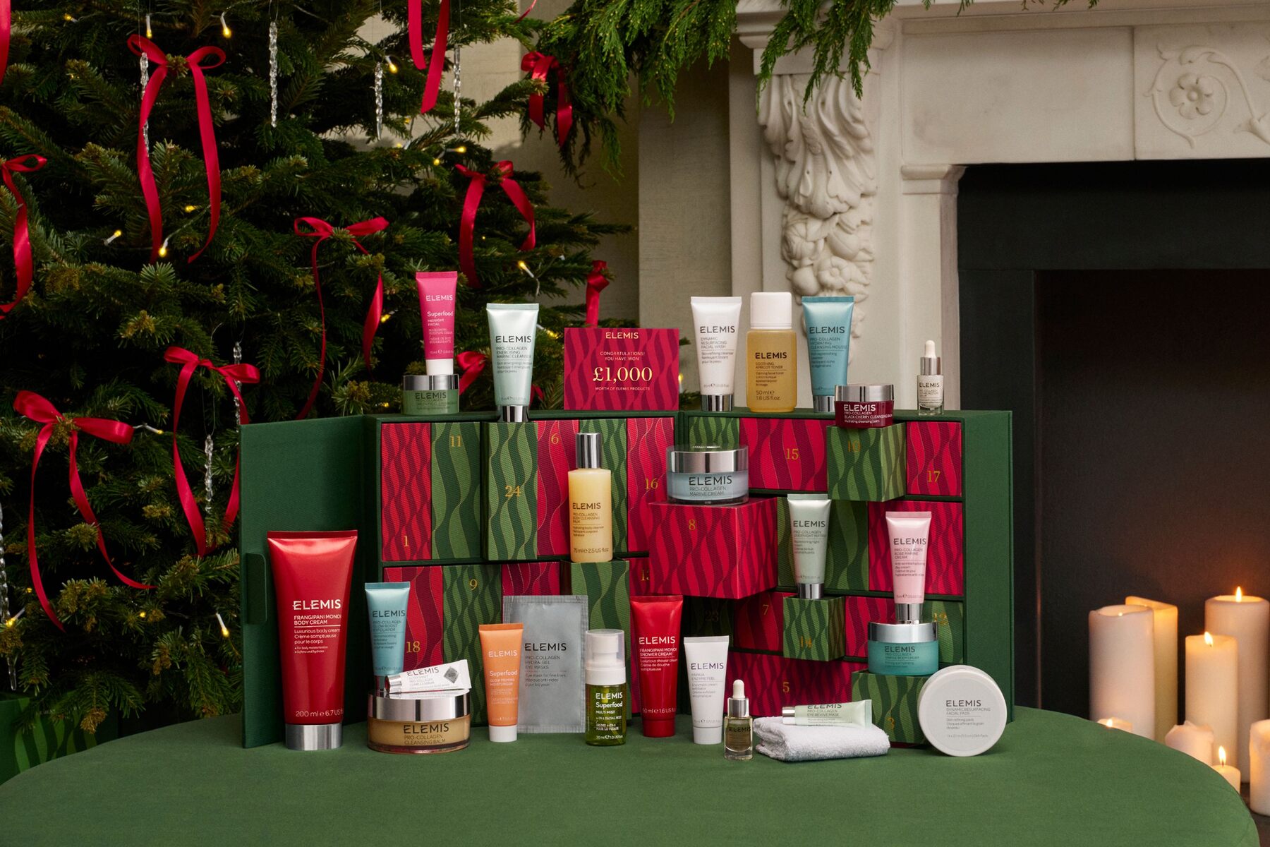 The open ELEMIS Ultimate Beauty advent calendar 2026 with its products in front, in a living room with a Christmas tree and candles