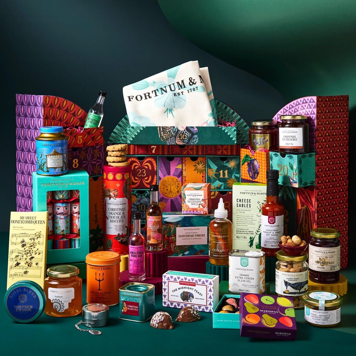 Fortnum and Mason jars, tins and treats arranged in front of a festive backdrop