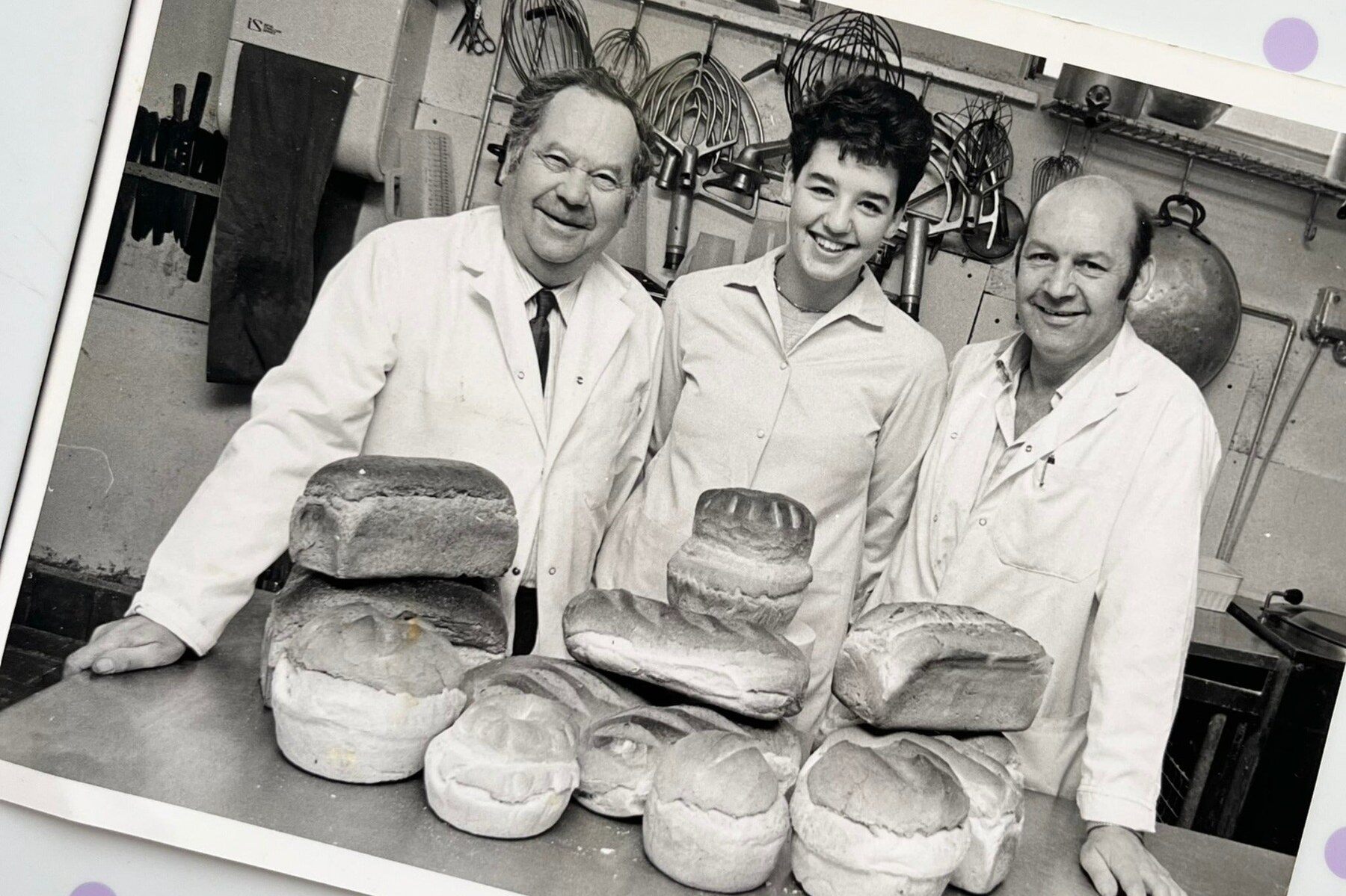 Black and white photo of three bakers with loaves at Gardners Bakery
