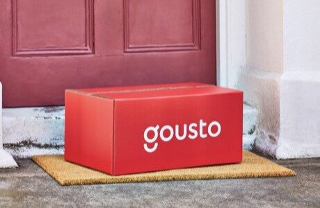 A red Gousto recipe box on a doorstep