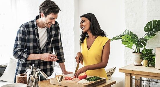 A couple cooking a HelloFresh recipe together in a bright kitchen