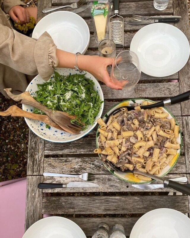 Friends sharing a HelloFresh creamy pasta dinner around a table