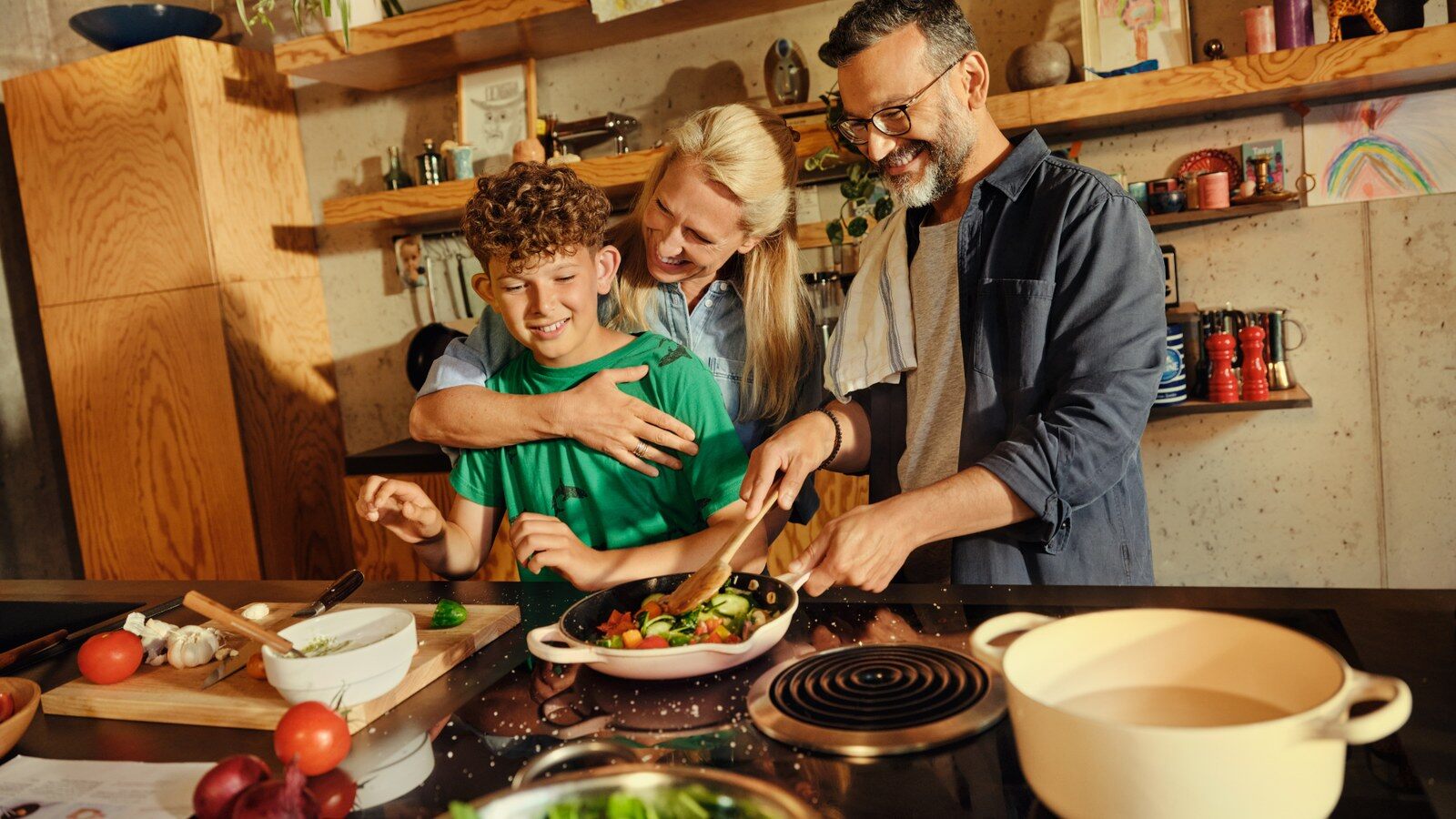 A father and two children cooking a meal together in a kitchen