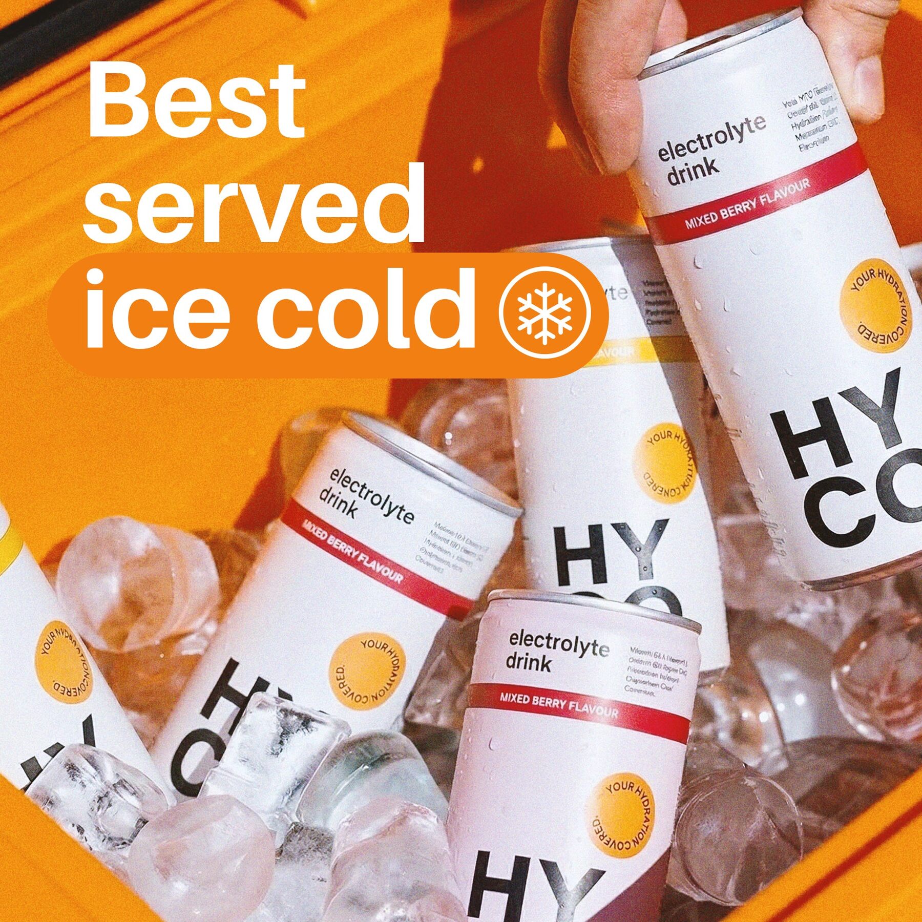 Several HYCO cans standing in a pile of ice cubes on an orange background