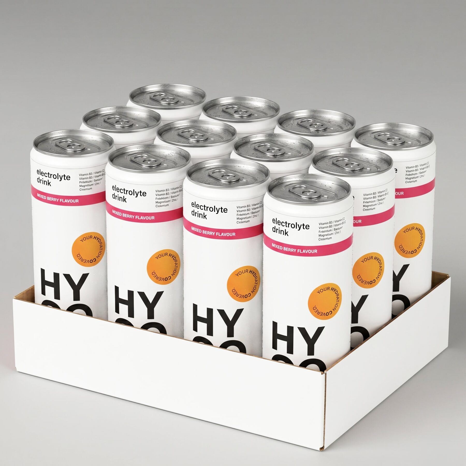 Twelve white HYCO Mixed Berry cans in an open cardboard tray on a grey background
