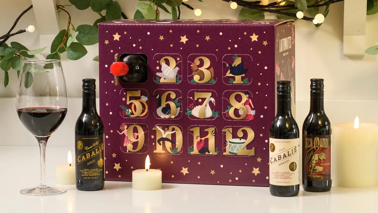 The purple Laithwaites 12 Days of Smooth Reds advent calendar with bottles of red wine, a glass and candles