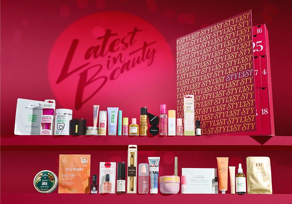 The Latest in Beauty x Stylist advent calendar 2026 in red with its products lined up on a shelf in front