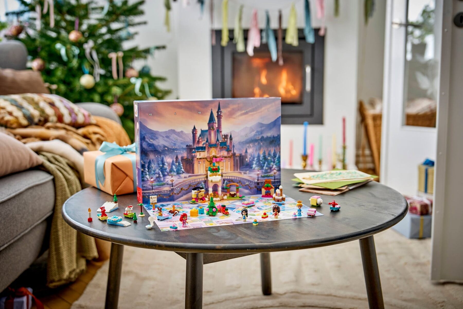 The LEGO Disney Princess advent calendar on a coffee table with a Christmas tree behind
