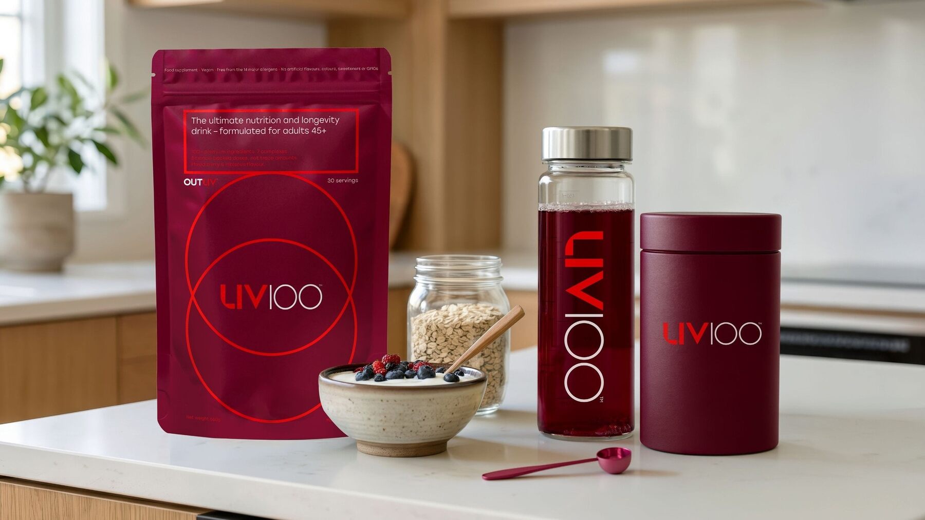 Liv100 pouch, shaker bottle and tin on a kitchen worktop beside a bowl of yoghurt and berries