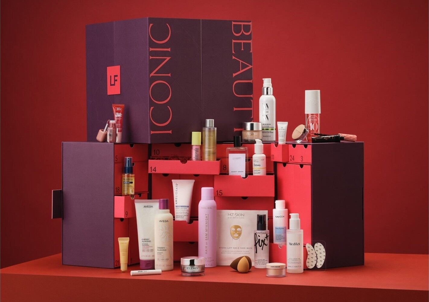The LOOKFANTASTIC 2026 beauty advent calendar open on a red set, with its drawers out and products in front