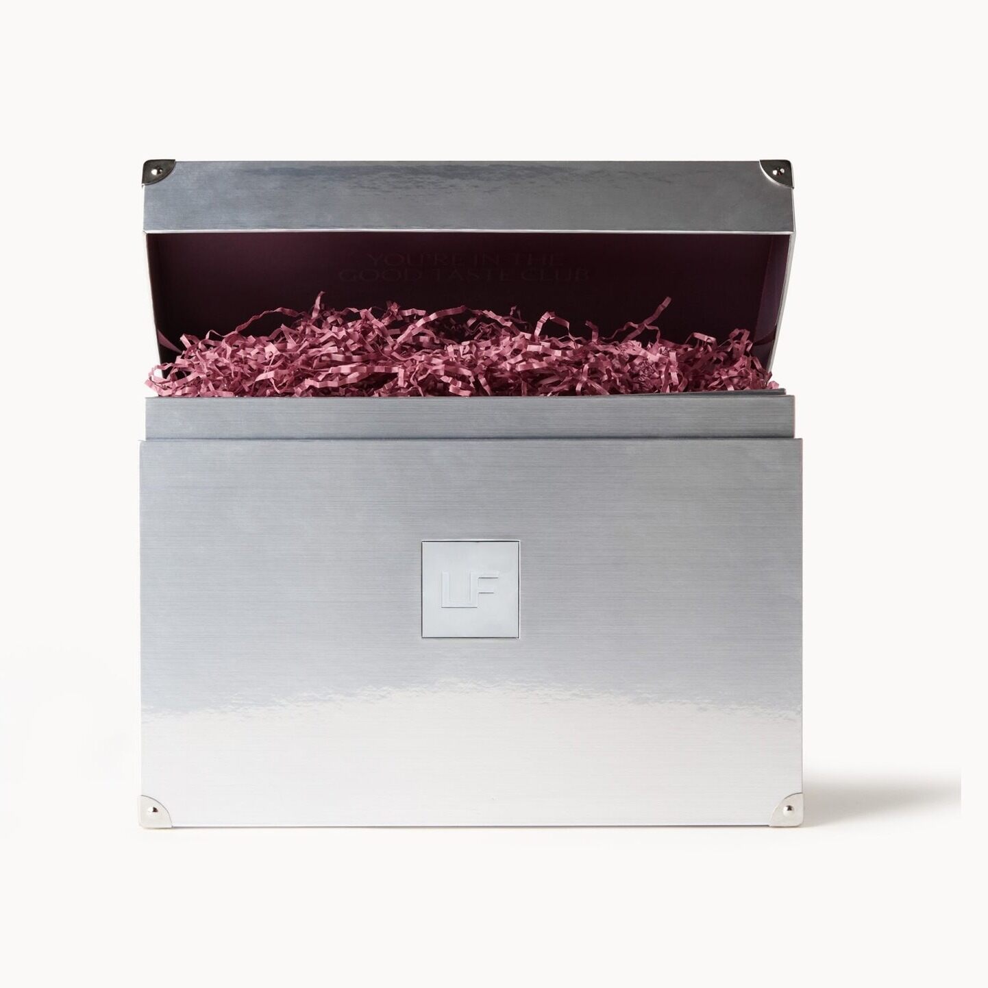 The closed silver LOOKFANTASTIC Beauty Vault box with its lid open and burgundy shredded paper inside
