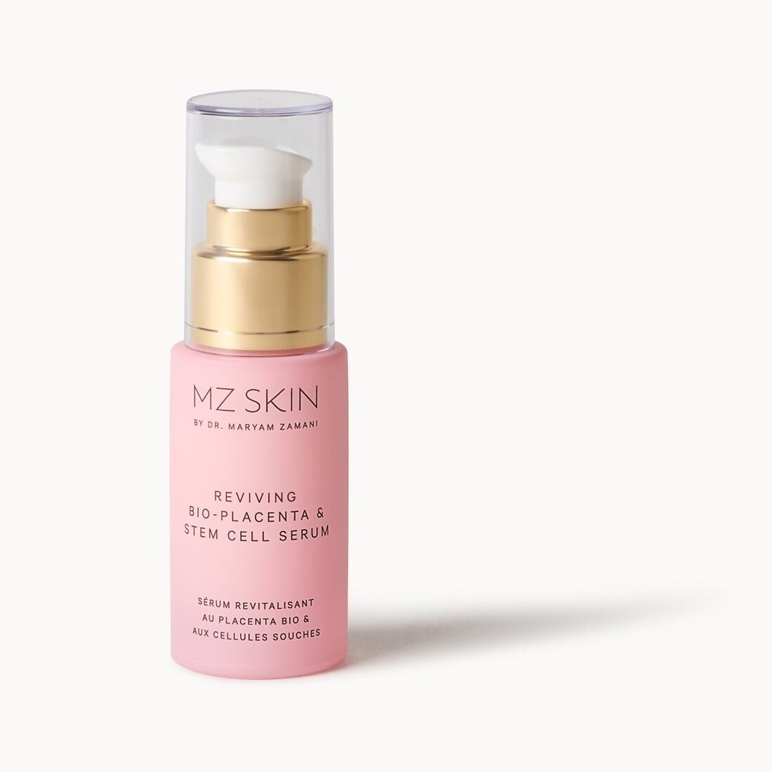 A pink MZ Skin Reviving Bio-Placenta and Stem Cell Serum bottle with a gold pump