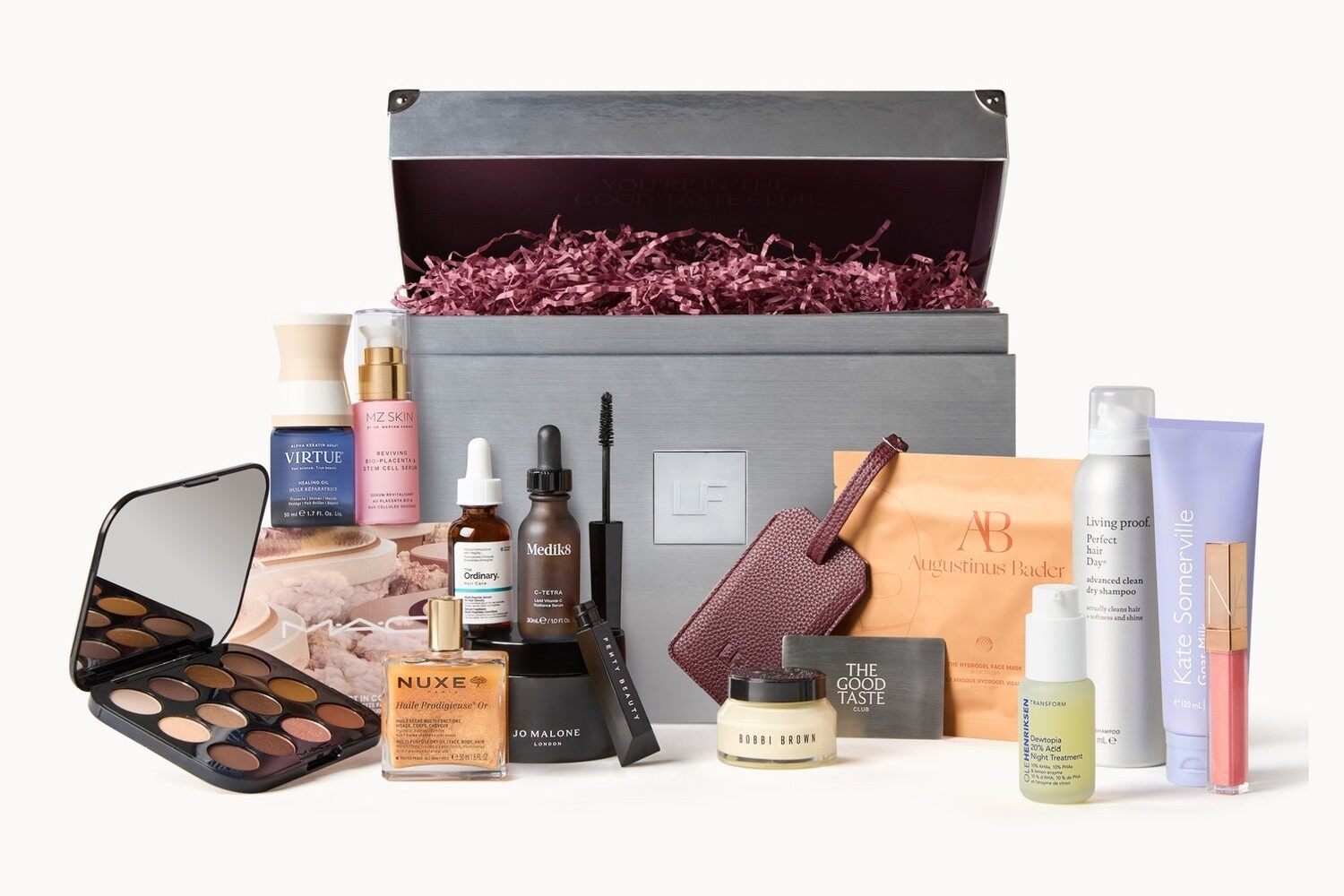 The LOOKFANTASTIC Beauty Vault 2026 silver box open behind its 14 products, including a MAC palette, Jo Malone London balm, Medik8 serum and NUXE oil
