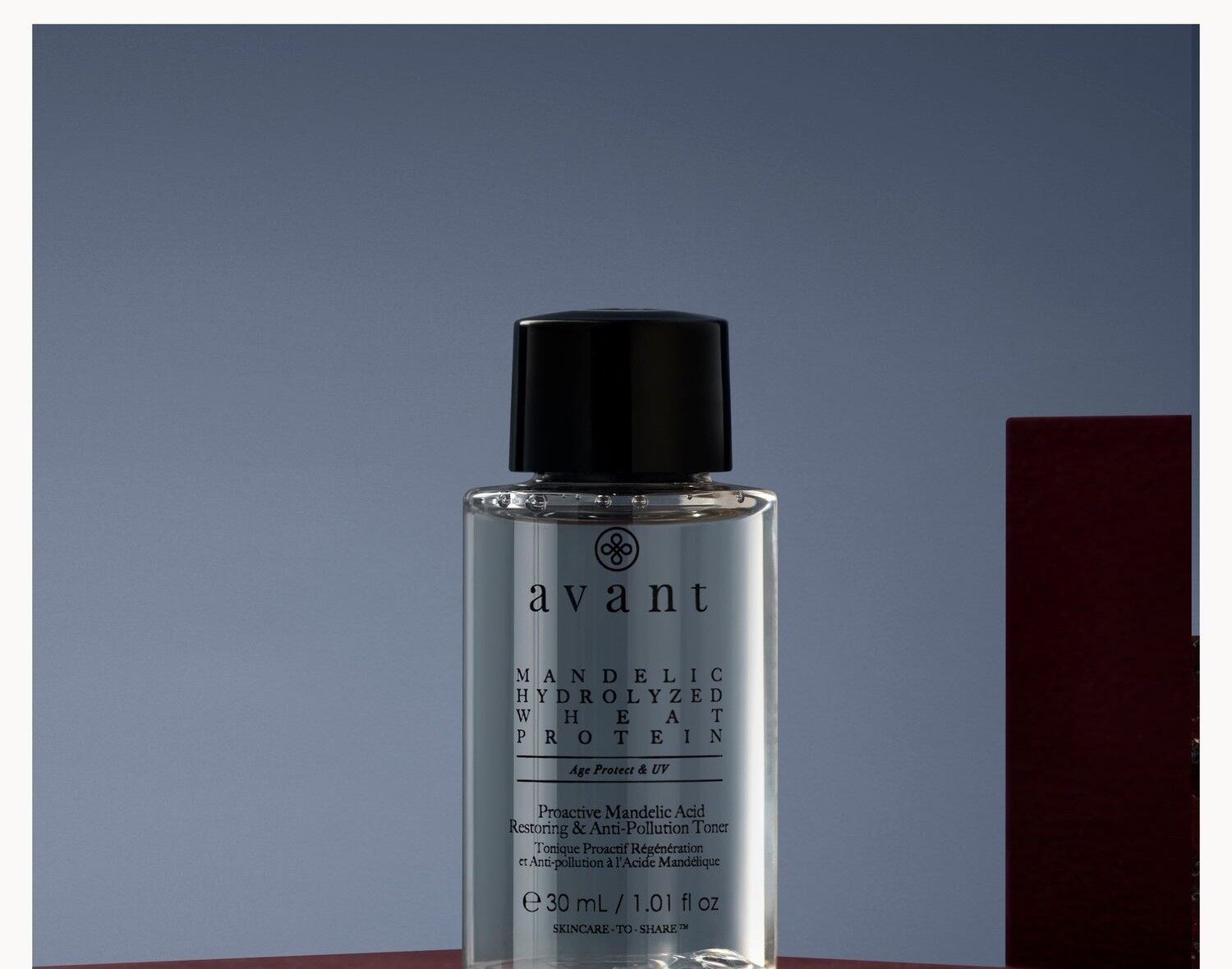 A small bottle of Avant Skincare mandelic acid toner on a burgundy block