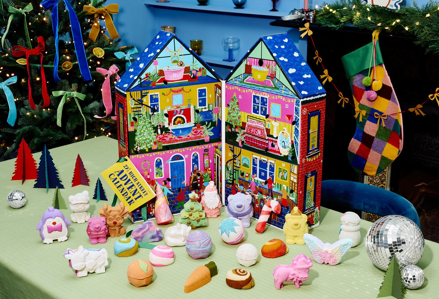The 29½ High Street Advent Calendar 2026 house open on a green table, surrounded by its bath bombs and bubble bars