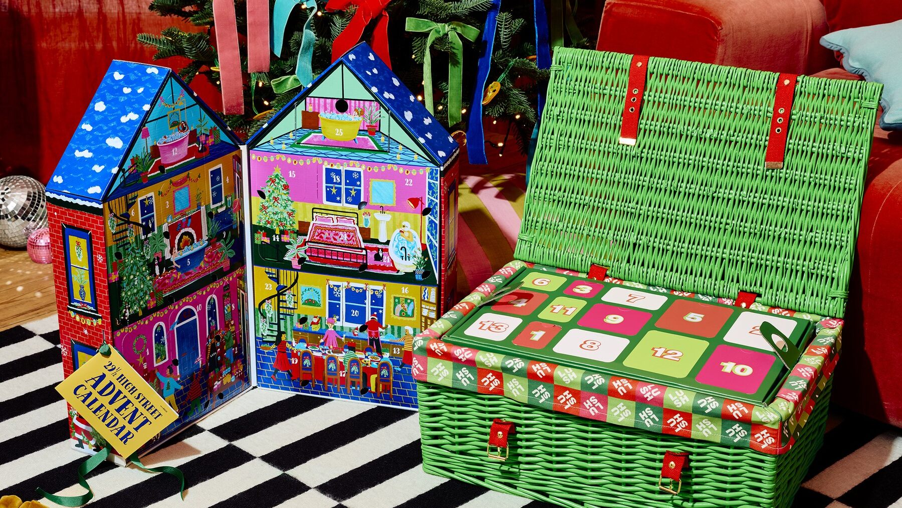 The Lush advent calendars for 2026 under a Christmas tree: two illustrated house calendars and the green wicker hamper