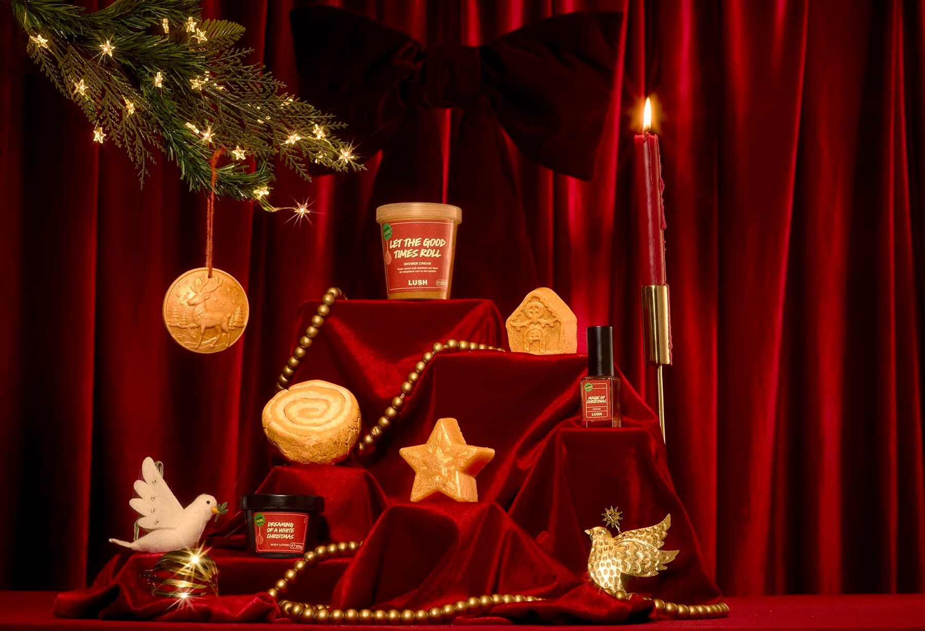The Lush Club December 2026 products on red velvet with gold baubles, candles and a Christmas wreath