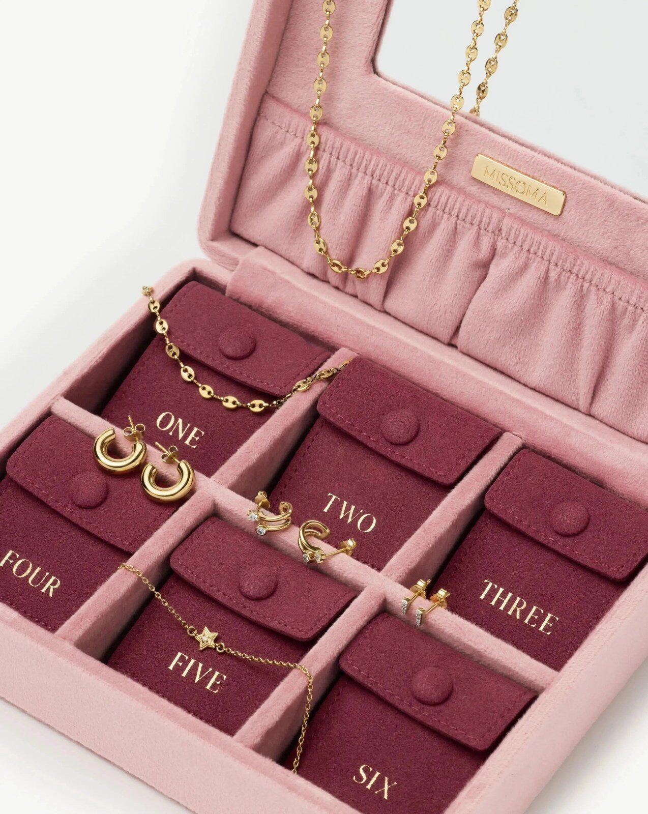 The open Missoma 2026 advent calendar, a dusky pink velvet case with burgundy compartments holding gold jewellery