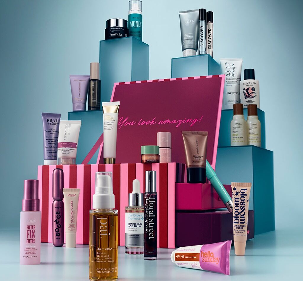 The M&S 2026 beauty advent calendar, a pink striped box reading You look amazing, surrounded by its products on blue blocks