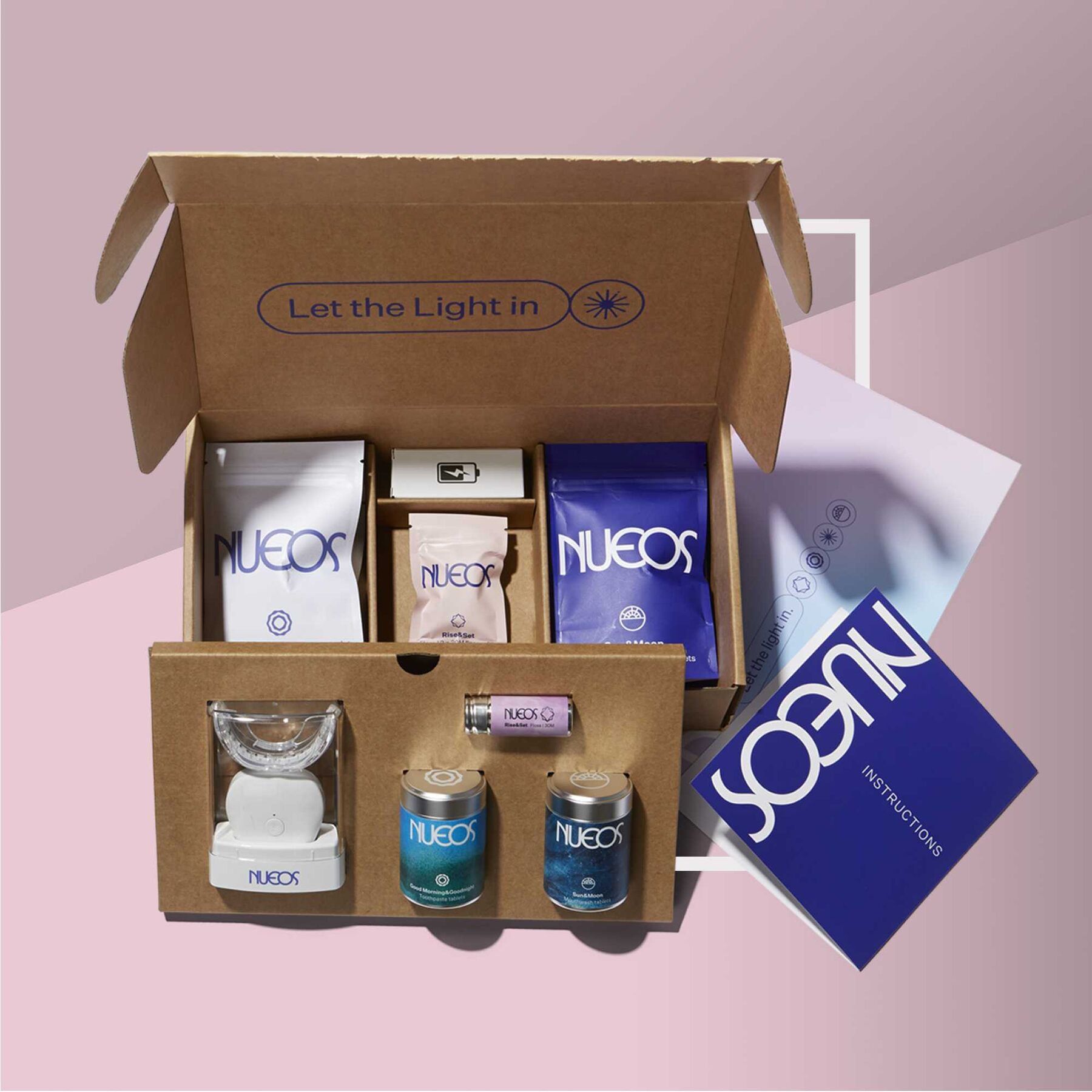 An open NUEOS Starter Kit box with the Light Bath device, storage tins, floss and tablet sachets