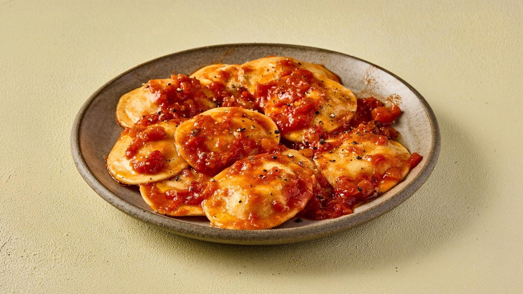 Pasta Evangelists Venetian style cod ravioli with tomato and basil sauce on a plate
