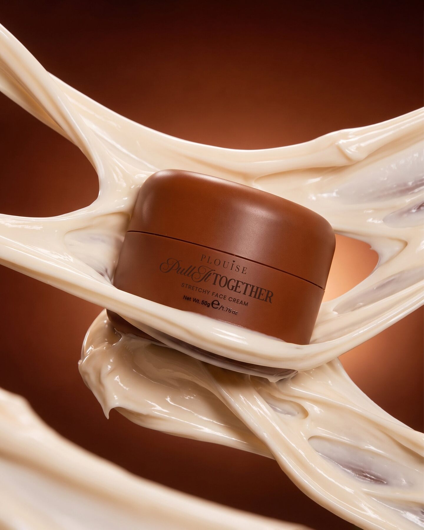 A jar of P.Louise Brightening and Repairing Stretchy Face Cream surrounded by a swirl of cream on a brown background