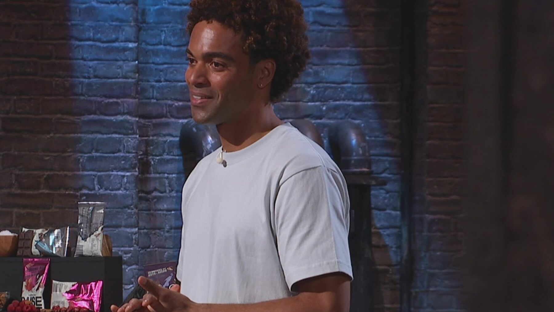 RAISE founder Chester Robinson pitching in the Dragons' Den with bags of nut and seed clusters behind him