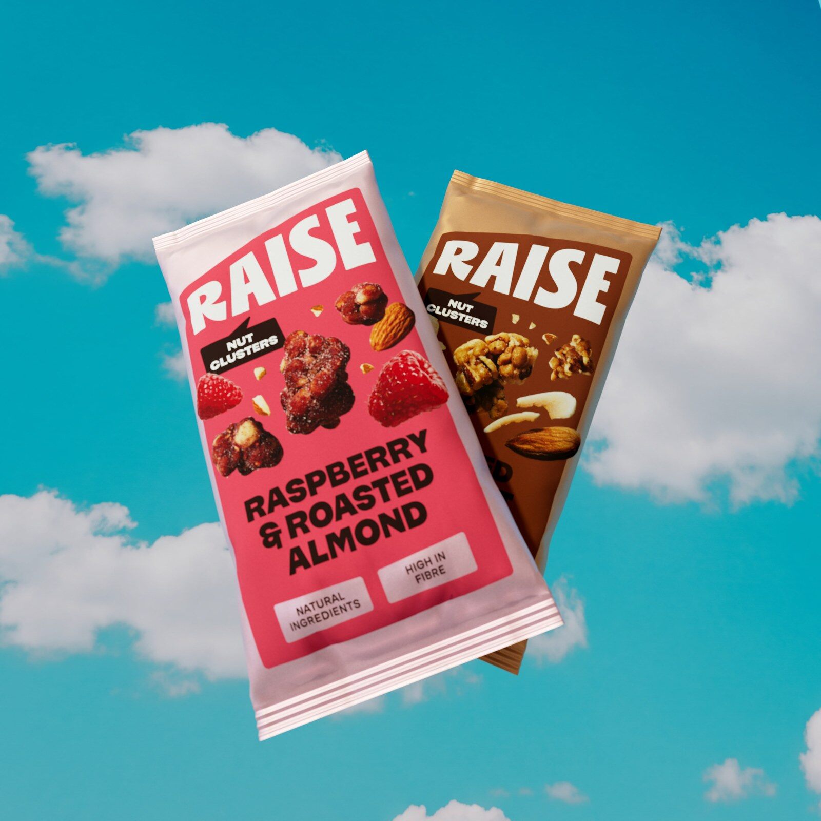 A blue bag of RAISE nut and seed clusters with chocolate clusters tumbling out against a sky background