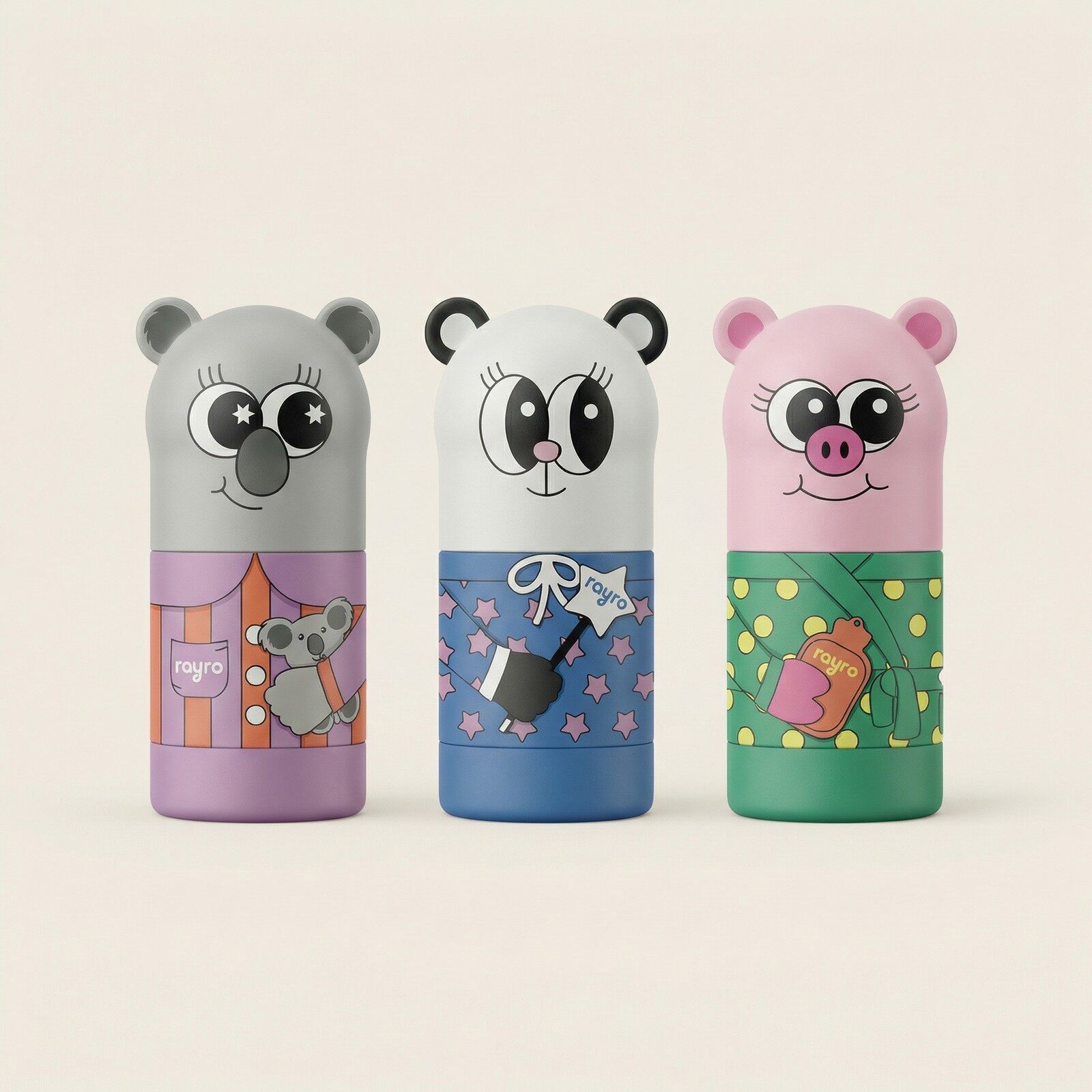 The three Rayro balm sticks, a grey koala, a white panda and a pink pig, standing side by side