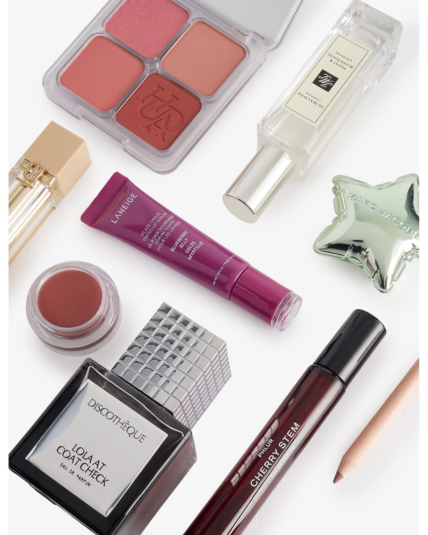 A close-up of products from the Selfridges calendar, including a Huda Beauty blush palette, a Jo Malone London cologne, a Discotheque perfume and lip products