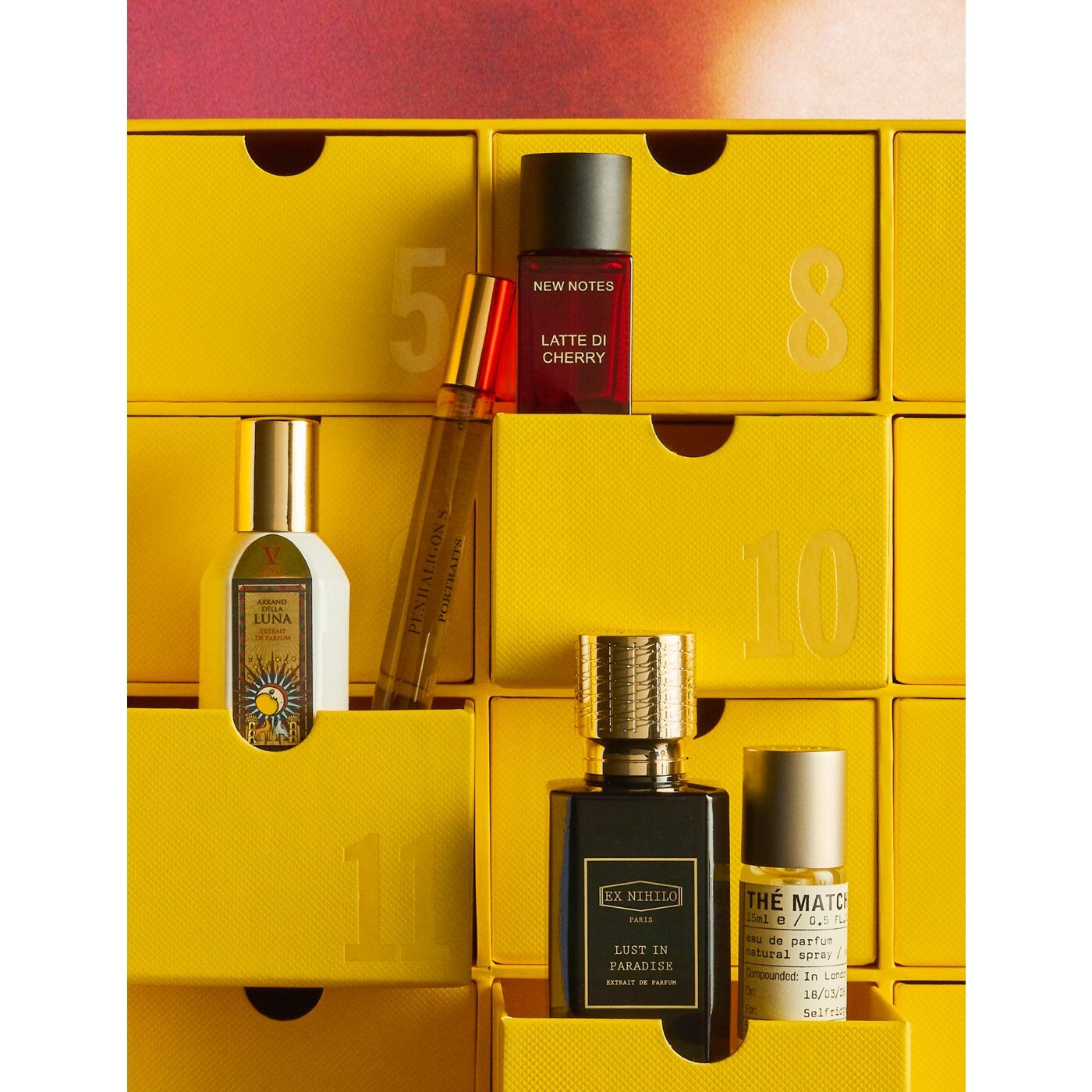 Perfume bottles from New Notes, Ex Nihilo and Le Labo sitting in the open yellow drawers of the Selfridges calendar