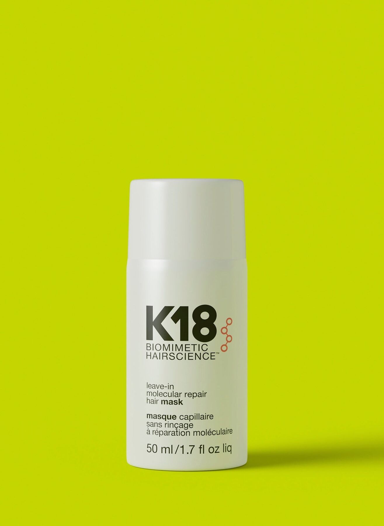 A white bottle of K18 Leave-in Molecular Repair Hair Mask on a light background