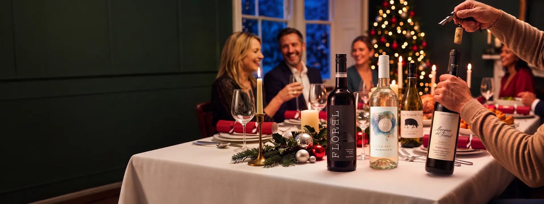 Friends raising a glass of wine around a Christmas dinner table