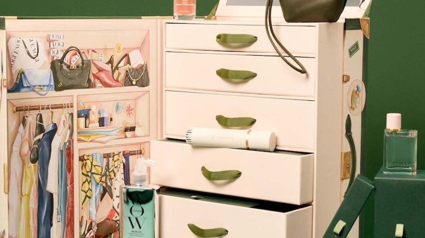 The Vogue Festive Calendar 2026 trunk open, with its drawers, illustrated wardrobe and Color Wow, Therabody and Burberry products