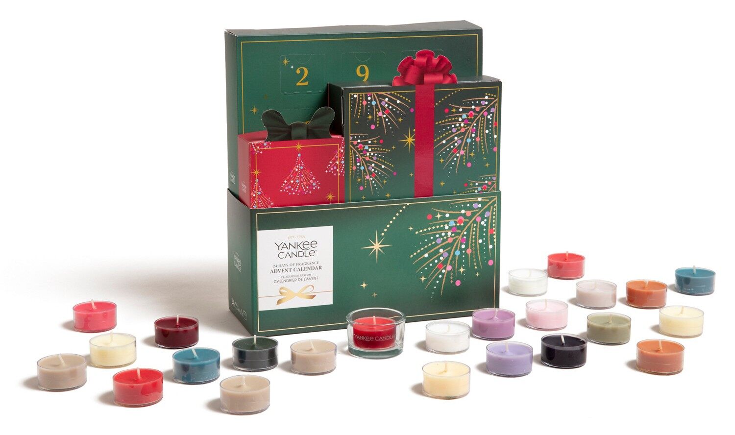 The Yankee Candle 24 Days of Fragrance advent calendar, a green box with gift-shaped drawers, surrounded by 24 coloured tea lights and a glass holder